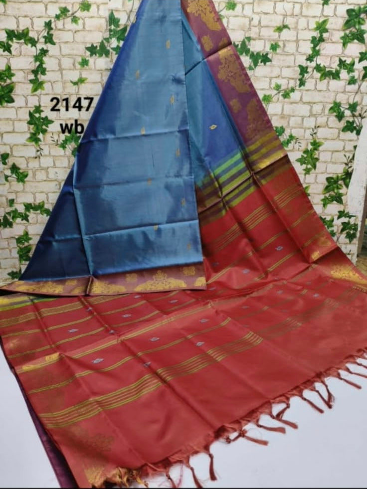 A beautiful trendy blue saree with gold motifs and a red border. Vegan Vaazhaipattu pudavai.